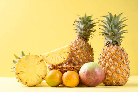 Fresh pineapple fruit, orange and star apple on yellow background, Tropical fruitの写真素材