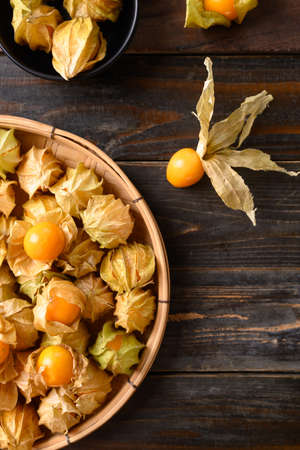 Cape gooseberry or golden berry (Physalis peruviana) on wooden background, Healthy tropical fruit, Table top viewの写真素材
