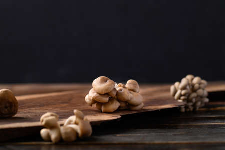 Local brown mushroom (Edible mushroom) on wooden background
