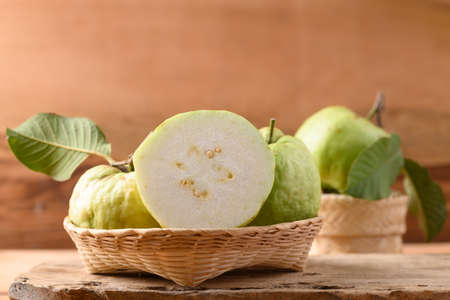 Fresh organic guava fruit in basket on wooden background, Tropical fruit