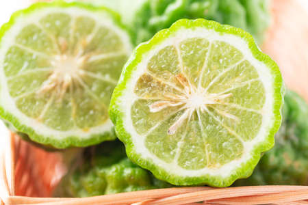 Organic Kaffir lime in basket, Citrus fruit used in Southeast Asian cuisine and essential oilの写真素材