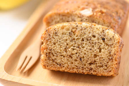 Banana bread on wooden plate with fork ready to eatingの写真素材