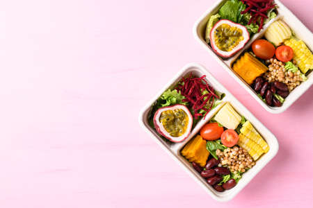 Fresh vegetables salad in biodegradable bowl on pink background, Healthy vegan foodの写真素材