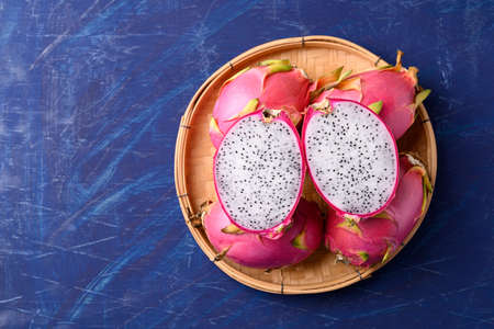 Fresh dragon fruit in basket on blue background, Tropical fruit in summer season, Top viewの写真素材