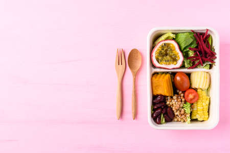 Fresh vegetables salad in biodegradable bowl on pink background, Healthy vegan foodの写真素材