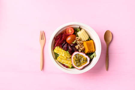 Fresh vegetables salad in biodegradable bowl on pink background, Healthy vegan foodの写真素材