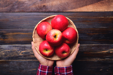 Red apple fruit in basket holding by hand, Healthy eating, Top viewの写真素材