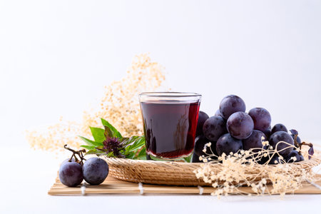 Black grape and juice in glass on white background, healthy drinkの写真素材