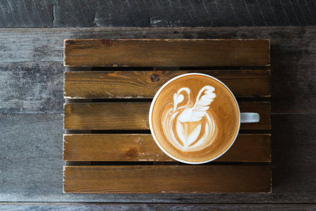 Latte art coffee with swan shape in coffee cup on wooden background, Hot drink, Table top view
