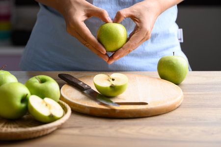 Hand holding green apple fruit with heart shape, Healthy eatingの写真素材