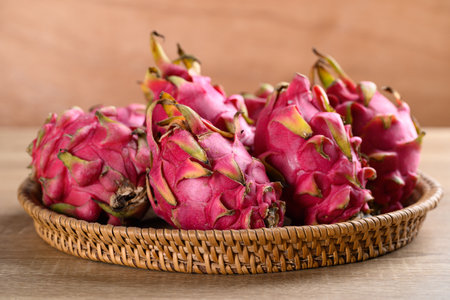 Red dragon fruit or pitaya in basket on wooden background, Tropical fruit in summer seasonの写真素材