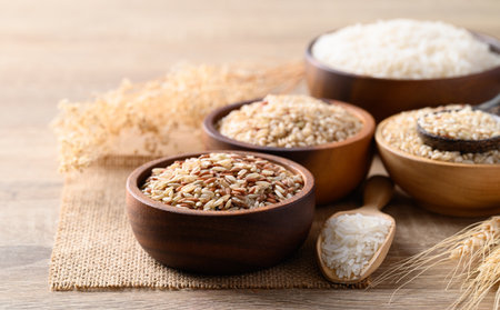 Thai brown rice seed in wooden bowl with spoon, Organic rice, Healthy food ingredient
