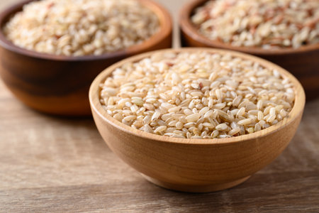 Thai brown rice seed in wooden bowl, Organic rice, Healthy food ingredientの写真素材