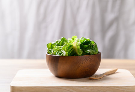 Organic cos romaine lettuce in wooden bowl, Food ingredient for healthy salad