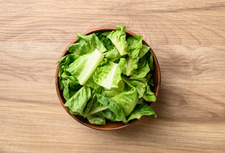 Organic cos romaine lettuce in wooden bowl, Food ingredient for healthy saladの写真素材