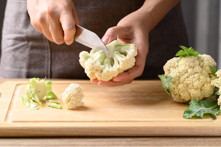 Hand holding knife and cutting organic cauliflower, Homemade cookingの写真素材