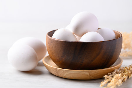 Organic white leghorn egg from free range farm in wooden bowl