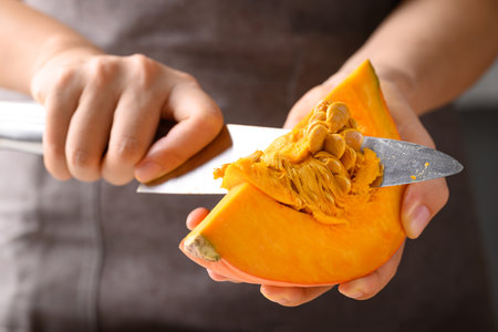 Orange Hokkaido pumpkin with hand holding knife for remove seed, Homemade cookingの写真素材