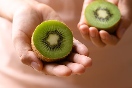 Green kiwi fruit holding by woman hand, Healthy eatingの写真素材