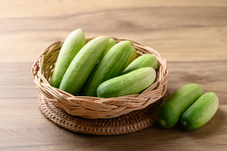 Fresh cucumber in basket on wooden background, Organic vegetable, Food ingredientの写真素材