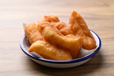 Asian deep fried dough in bowl on wooden background, Thai style breakfast