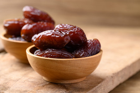 Date palm fruit (MedJool) in wooden bowl