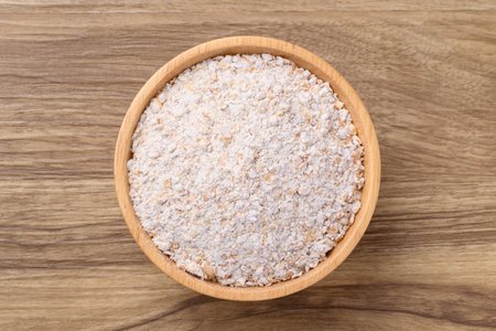 Whole wheat flour in bowl on wooden background, Table top viewの写真素材