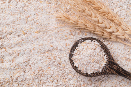 Whole wheat flour in spoon with flour background, Top viewの写真素材