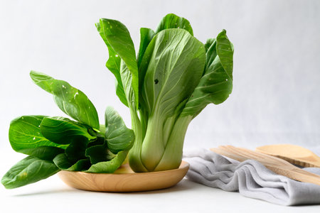 Organic Bok choy or Pak choi on wooden plate with white background, Fresh vegetable, Food ingredientの写真素材