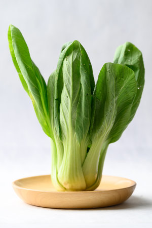 Organic Bok choy or Pak choi on wooden plate with white background, Fresh vegetable, Food ingredientの写真素材