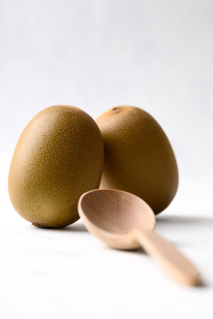 Fresh kiwi fruit with wooden spoon on white background, Healthy eatingの写真素材