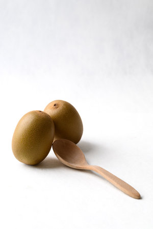 Fresh kiwi fruit with wooden spoon on white background, Healthy eatingの写真素材
