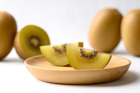 Sliced sungold kiwi fruit on wooden plate ready to eatingの写真素材