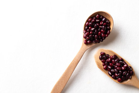Top view of raw Azuki beans or red mung beans in wooden spoon on white background, Food ingredientの写真素材