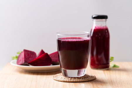 Fresh beetroot juice in glass and bottle on wooden board, Healthy drinkの写真素材