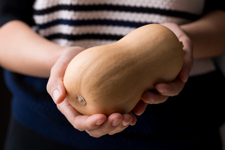 Butternut squash pumpkin holding by woman handの写真素材