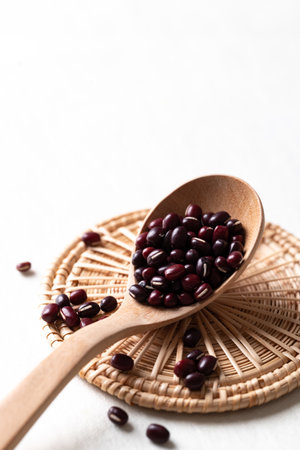 Raw Azuki beans or red mung beans in wooden spoon on white background, Food ingredientの写真素材