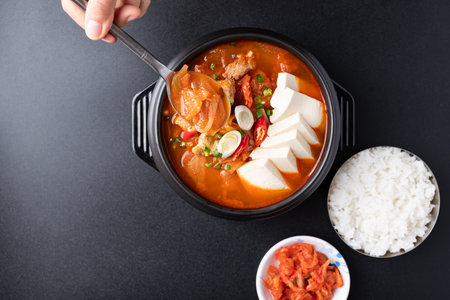Top view of Korean food (Kimchi Jjigae), Kimchi soup with tofu, pork, scallion and chili in Korean...