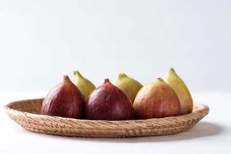 Fresh fig in basket on white background, Autumn fruitの写真素材