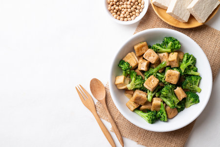 Stir fried tofu and broccoli with soy sauce in bowl on white background, Asian vegan food, Top viewの写真素材