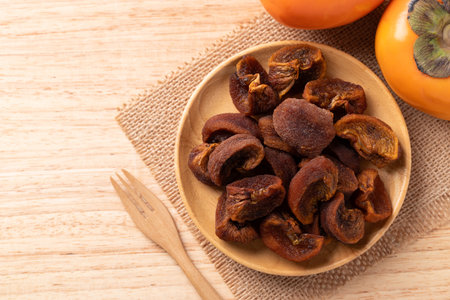 Dried persimmon on wooden plate ready to eating, Sweet and chewy, Tablet top viewの写真素材