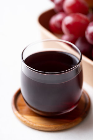 Red grape juice in glass and fresh grapes fruit on white background, Healthy drinkの写真素材