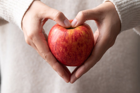 Red apple fruit (Envy apple) holding by woman hand (heart shape), Healthy eatingの写真素材
