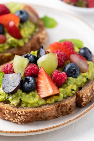 Avocado toast with strawberry, blueberry, raspberry and grape. Healthy eatingの写真素材