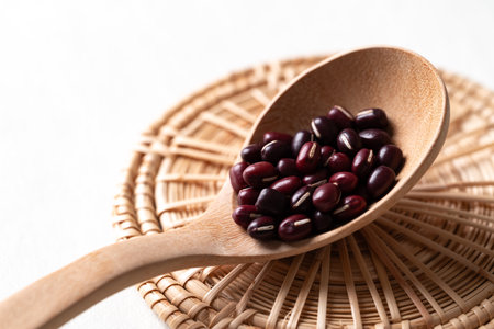 Raw Azuki beans or red mung beans in wooden spoon on white background, Food ingredientの写真素材