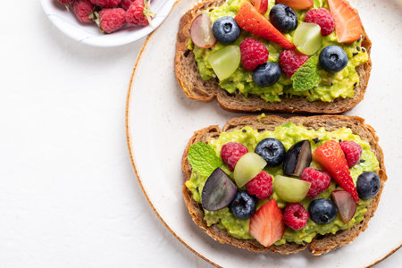 Top view of avocado toast with strawberry, blueberry, raspberry and grape.の写真素材