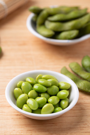 Boiled Edamame beans (Japanese soybeans) in a bowl on wooden backgroundの写真素材