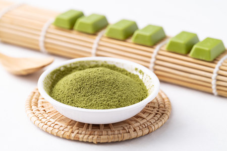 Matcha powder and chocolate bar on white background