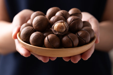 Macadamia nuts in a bowl holding by handの写真素材