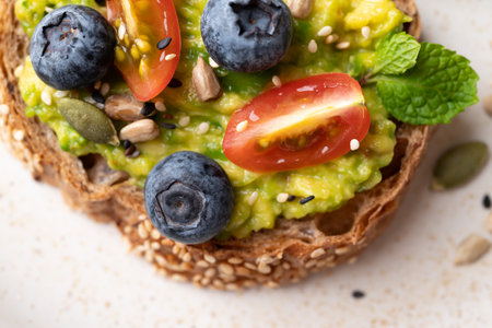 Avocado toast with blueberries, cherry tomatoes, sunflower seeds, pumpkin seeds, sesame seeds and...